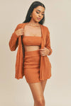 Rust Tube Top Sweater & Skirt Set. Features a tube top with shoulder straps, a mini skirt, and a button-front cardigan.